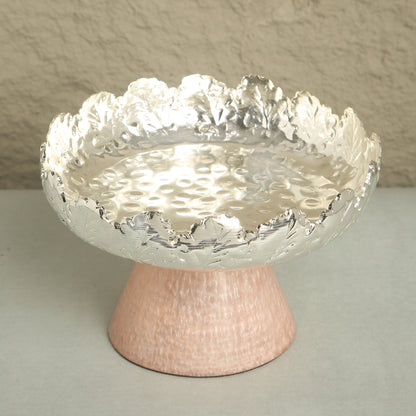 Decorative bowl with textured surface on a stand against a neutral background