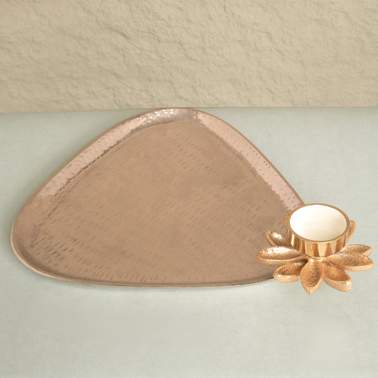 Decorative copper tray with a floral design on a light green surface