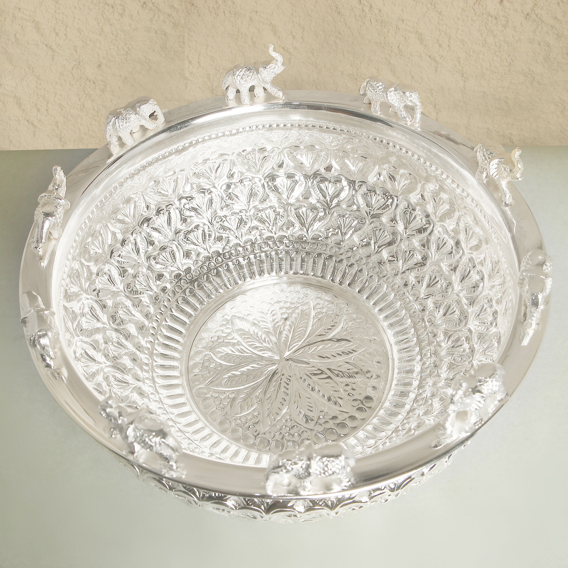 Decorative silver tray with intricate patterns on a light background