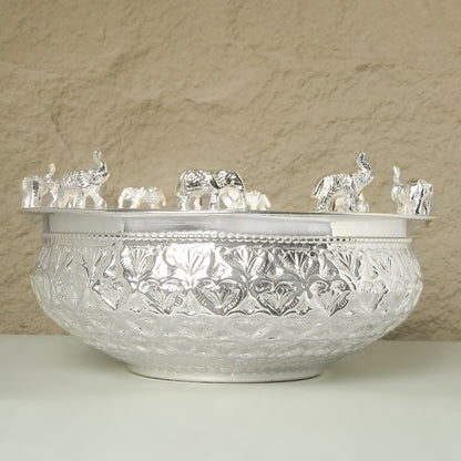 Decorative crystal bowl with intricate patterns and small crystal elephants on a beige background