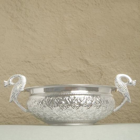 Silver bowl with decorative handles on a beige background