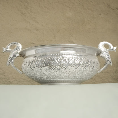 Decorative silver bowl with handles on a beige background