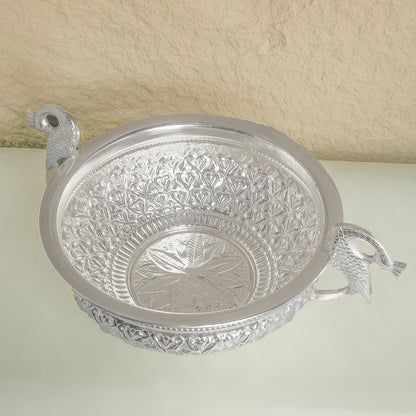 Decorative silver bowl with intricate patterns on a light background