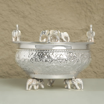 Decorative silver bowl with elephant designs on a neutral background
