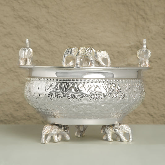 Decorative silver bowl with elephant designs on a neutral background
