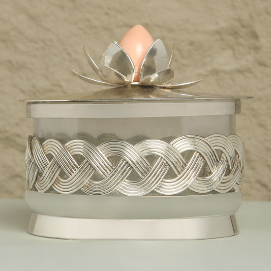 Decorative container with silver lid featuring a floral design on a neutral background