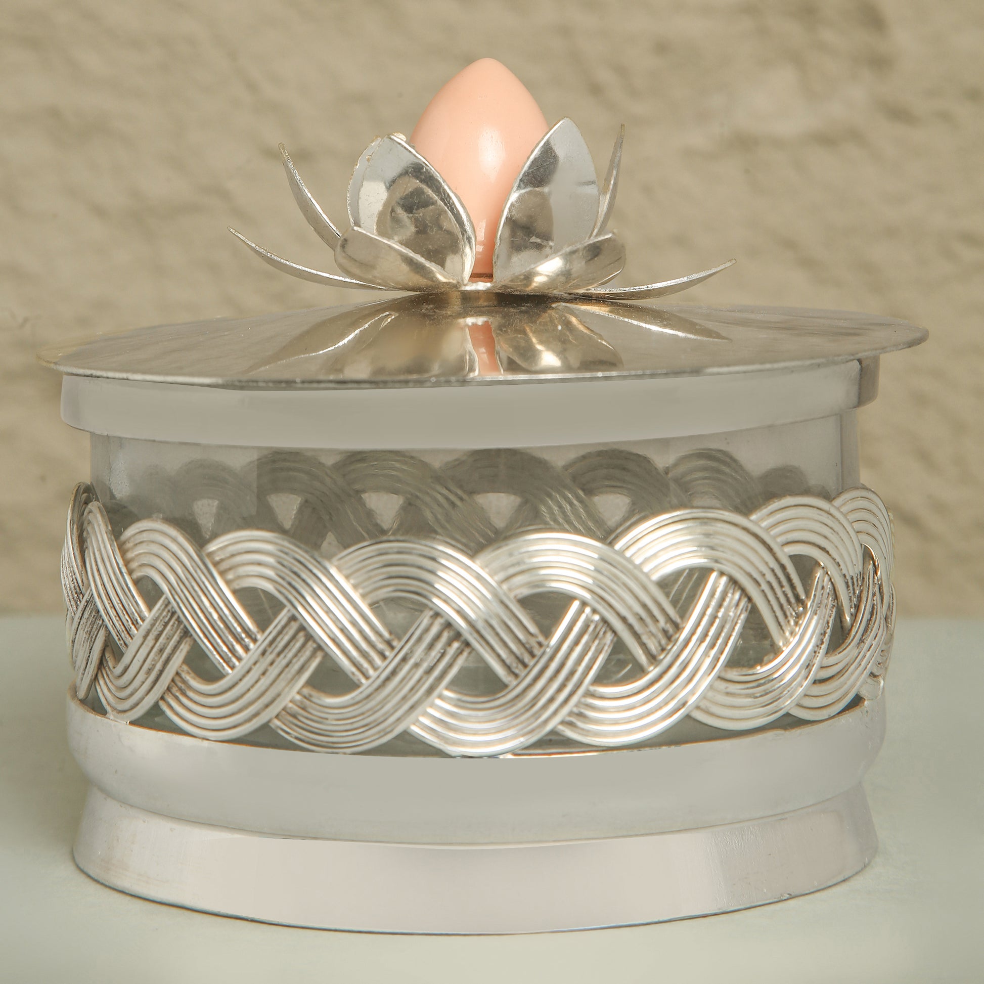 Decorative silver box with a pink egg on a beige background