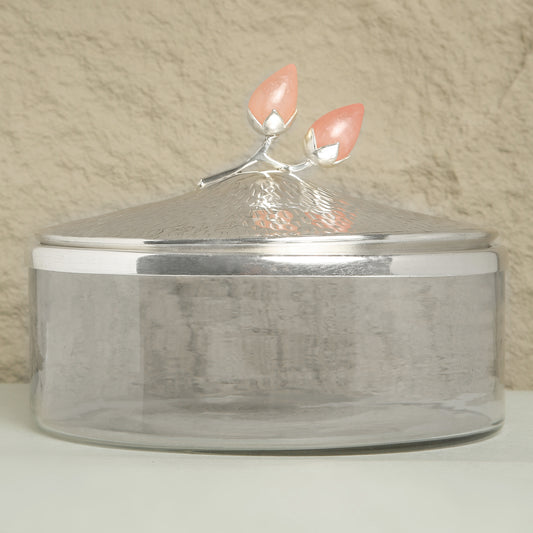 Silver container with a decorative lid featuring pink flowers on a beige background