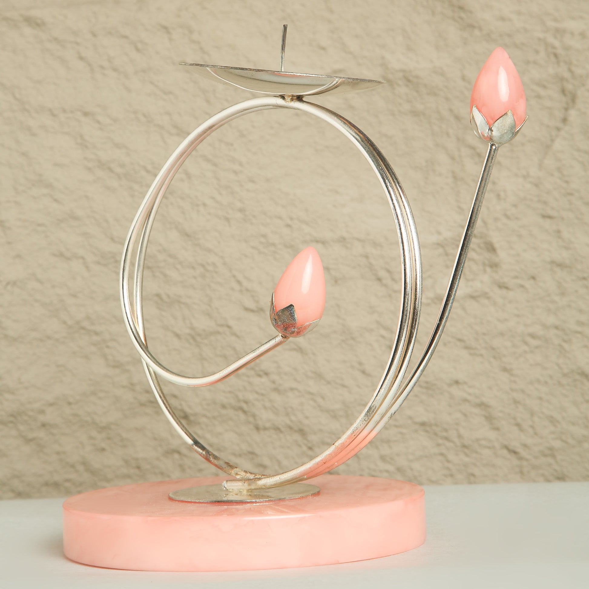 Decorative candle holder with pink candles on a beige background