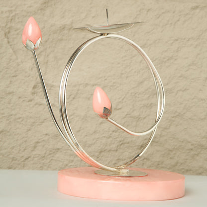 Decorative object with pink base and pink teardrop-shaped candles on a beige background