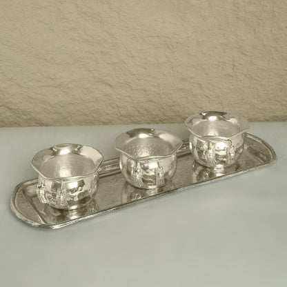 Set of silver tea cups and tray on a neutral background