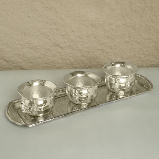 Set of silver tea cups and tray on a neutral background