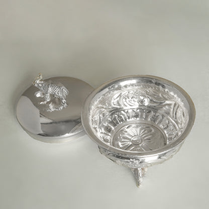 Silver decorative bowl with intricate designs on a light gray background