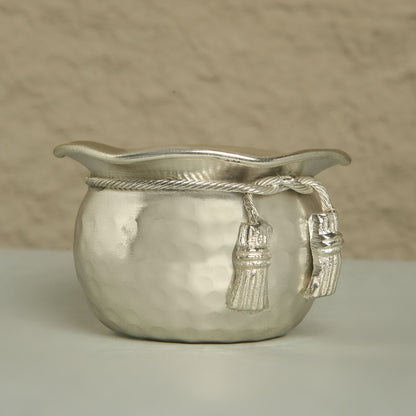 Silver decorative bowl with tassels on a neutral background