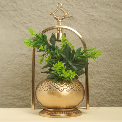 Decorative gold lantern with green plants against a beige background