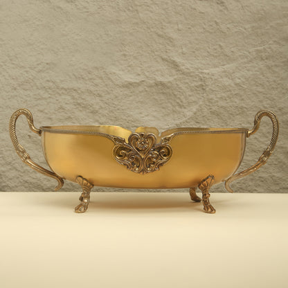 Decorative gold bowl with intricate designs on a beige background