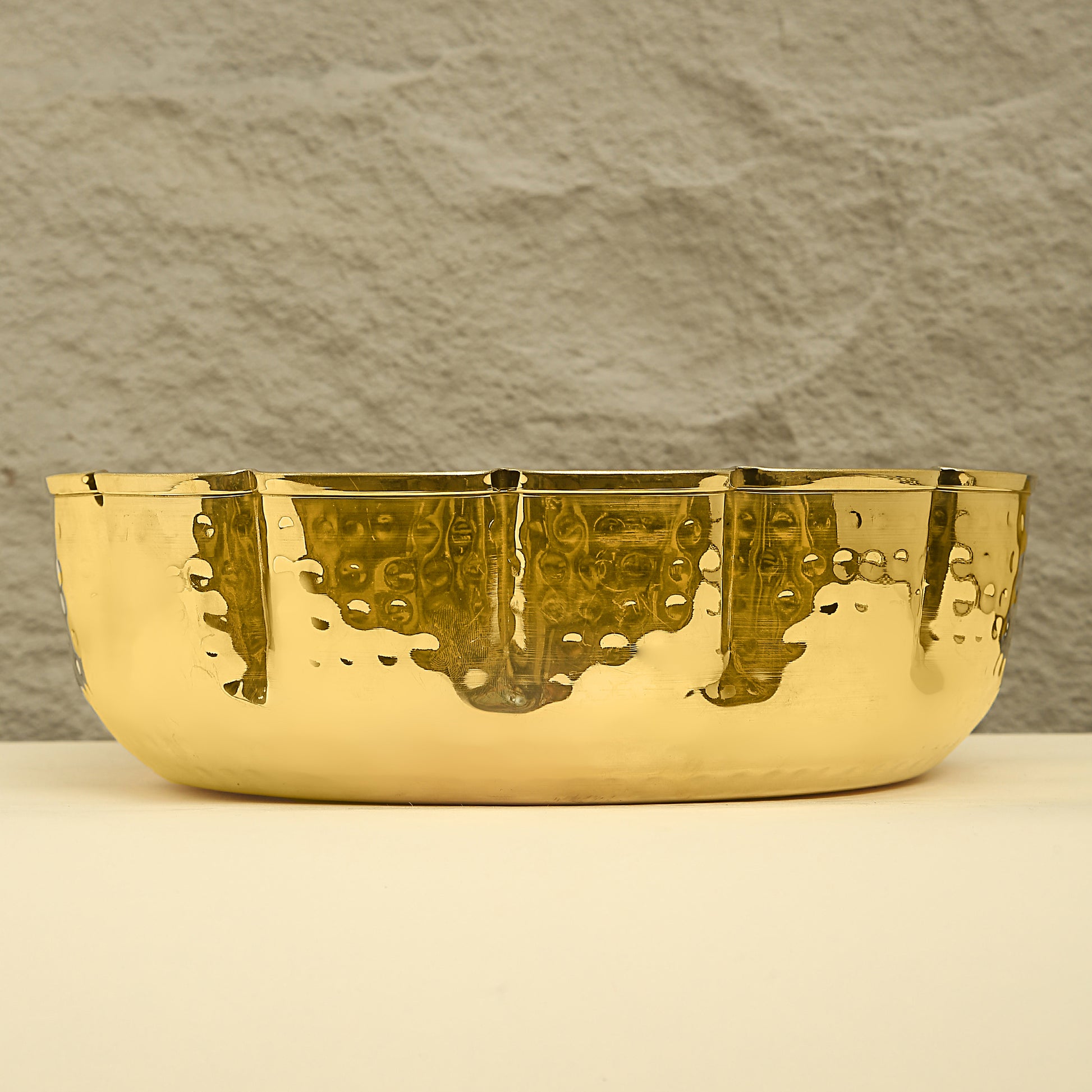 Gold bowl with textured surface on a neutral background