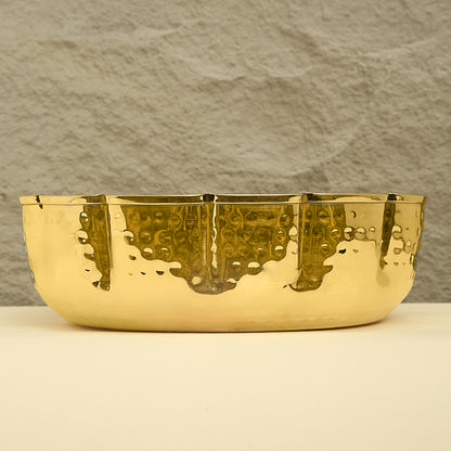 Gold bowl with textured surface on a neutral background