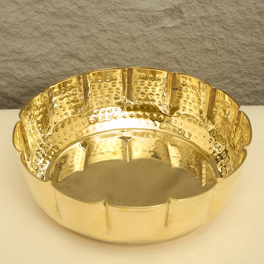 Gold decorative bowl with textured surface on a neutral background