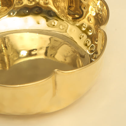 Gold ring with intricate design on a light beige background