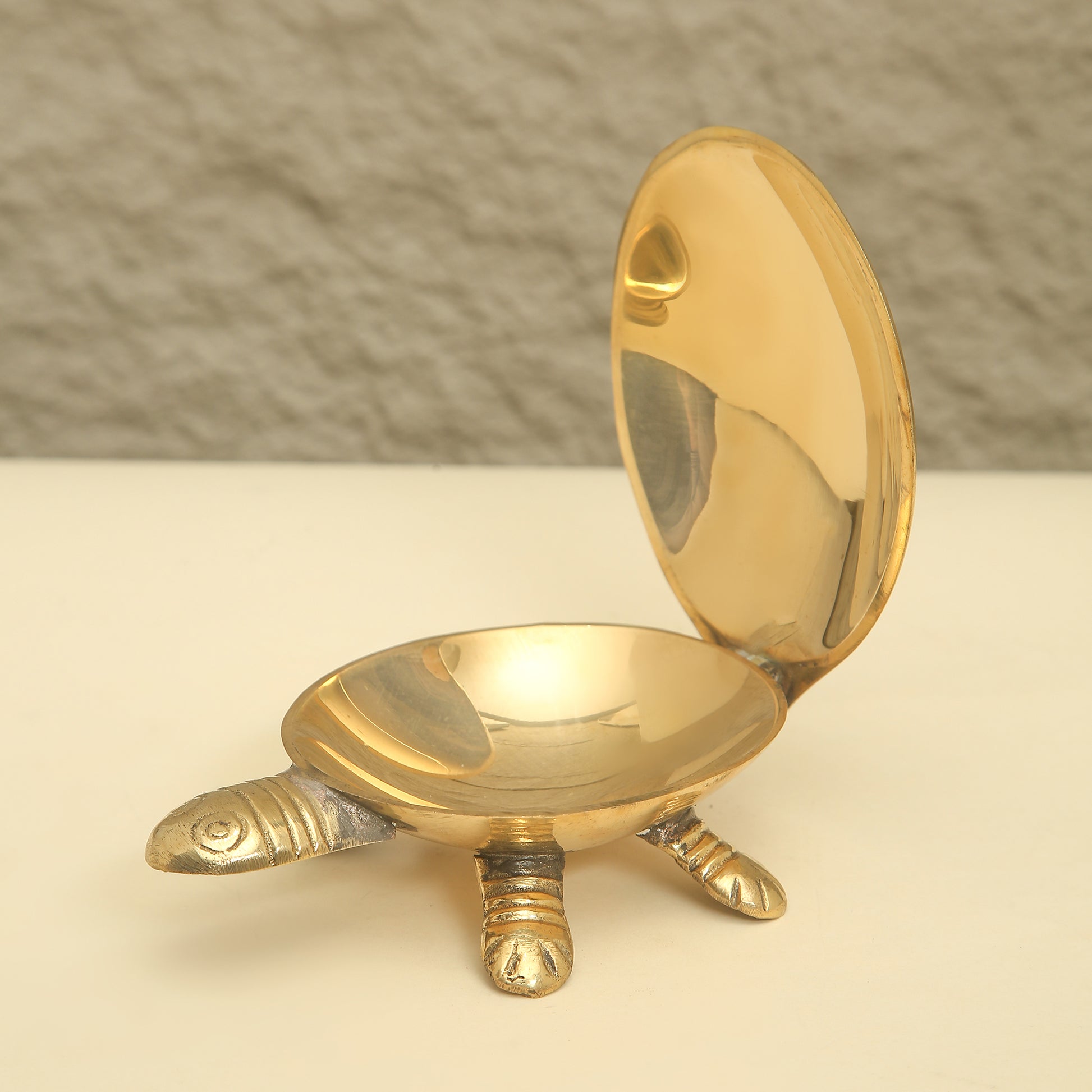 Gold turtle-shaped dish on a beige surface with a neutral background