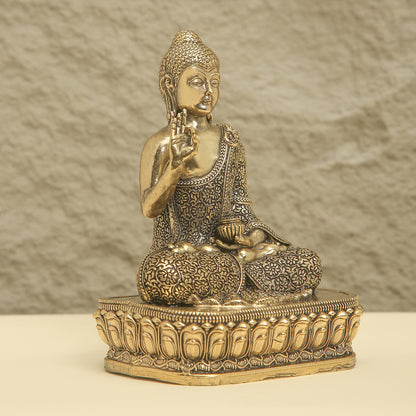 Bronze statue of a seated Buddha on a textured surface
