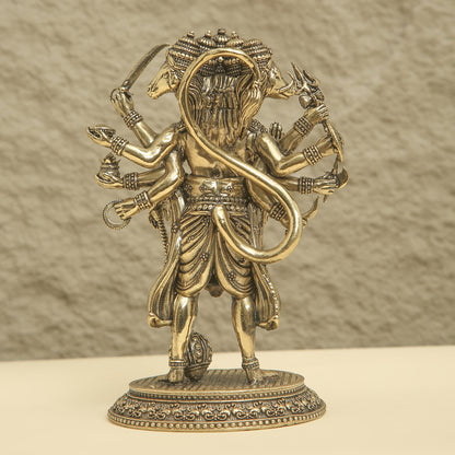 Bronze statue of a deity with multiple arms and a snake on a beige background