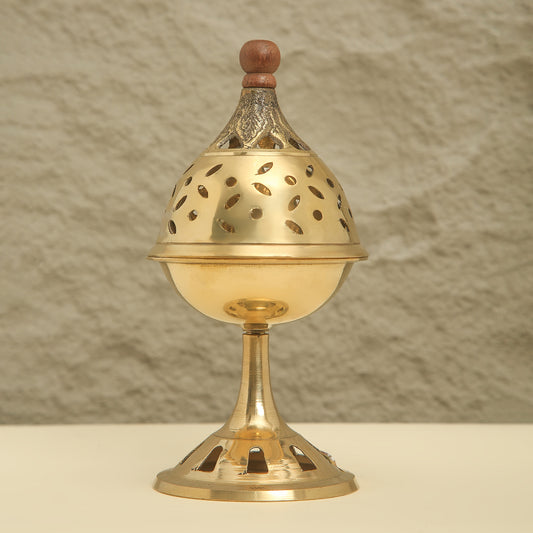 Brass incense burner with wooden top on a neutral background