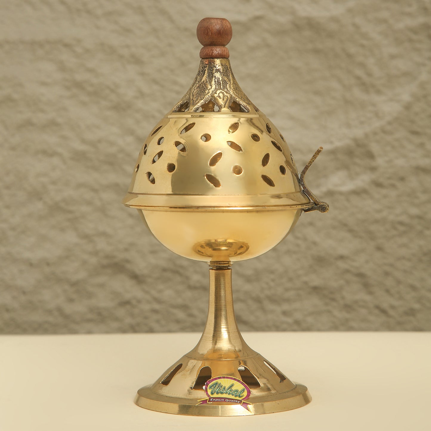 Brass incense burner with wooden top on a neutral background