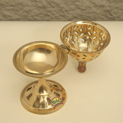 Two gold-colored metal objects on a white surface with a gray textured background