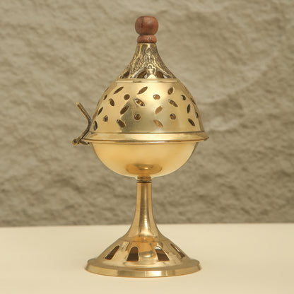 Brass incense burner with wooden top on a neutral background
