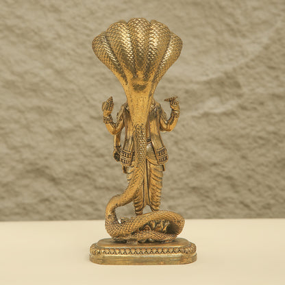 Bronze statue of a cobra with human figures on a textured background