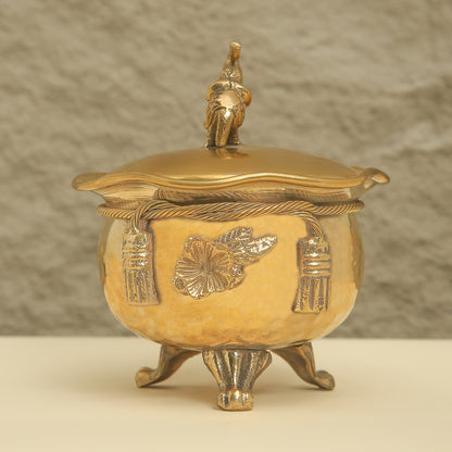 Gold decorative pot with lid on a beige background