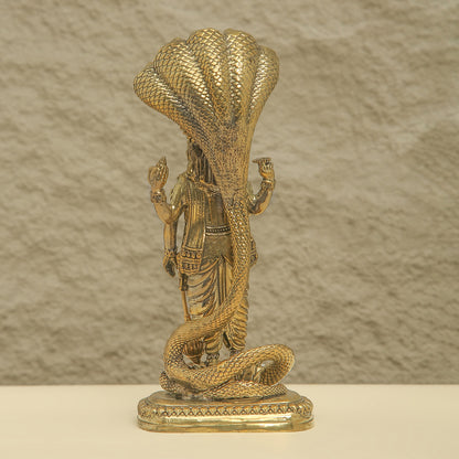 Bronze statue of a figure with a large snake draped over them against a textured beige background