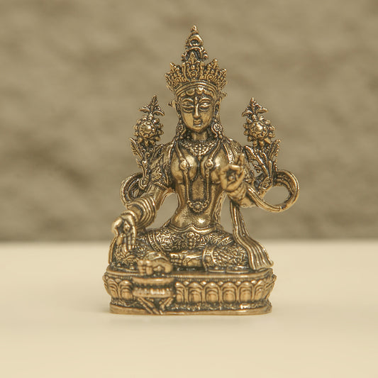 Bronze statue of a deity with intricate details on a beige background