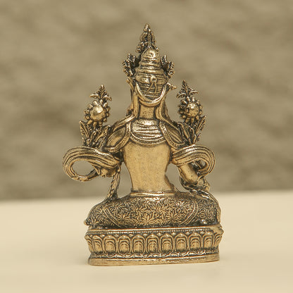 Bronze statue with intricate designs on a beige background
