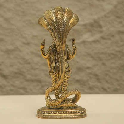 Bronze statue of a cobra with a person inside on a beige background