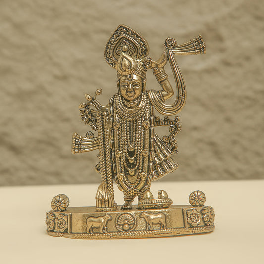 Gold-colored figurine of a deity on a beige background