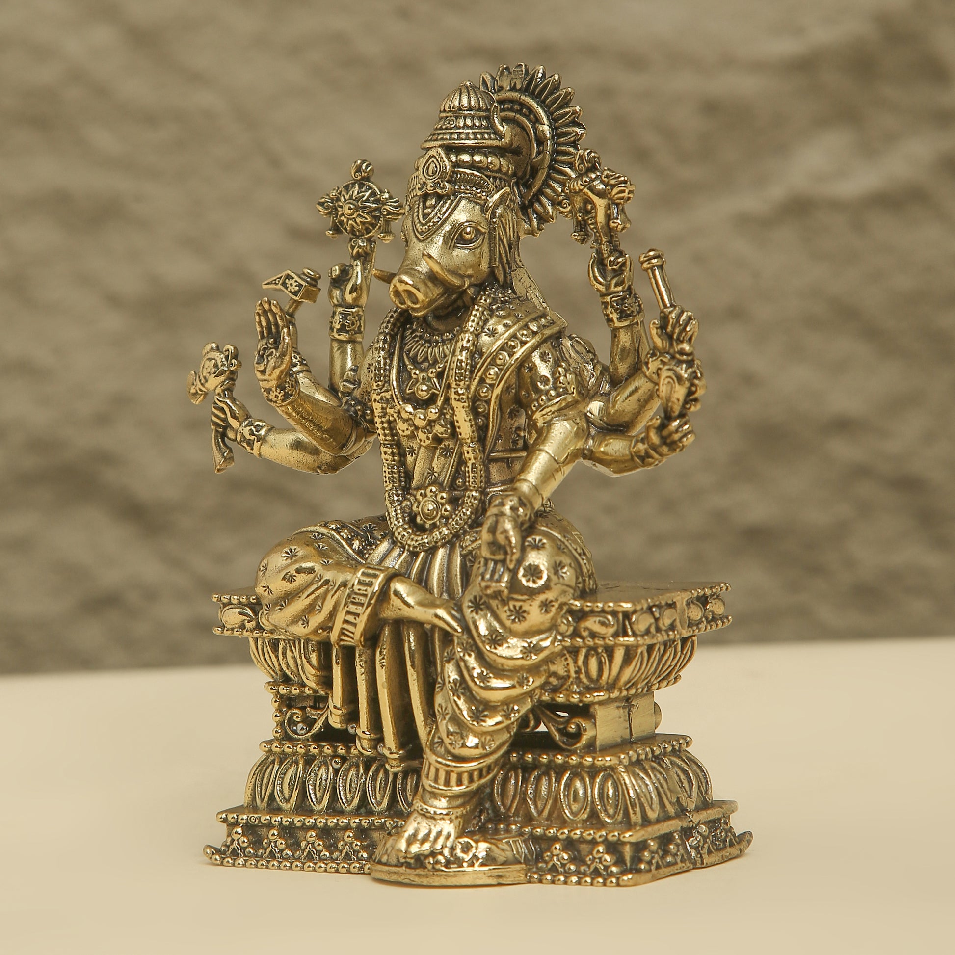 Decorative brass statue of a deity on a textured surface