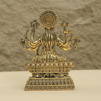 Decorative brass statue with intricate designs on a neutral background