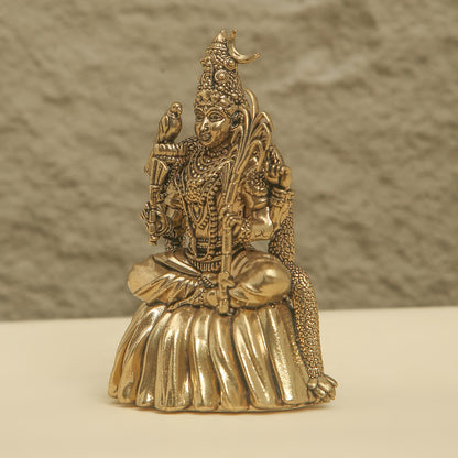 Gold-colored statue of a deity on a neutral background