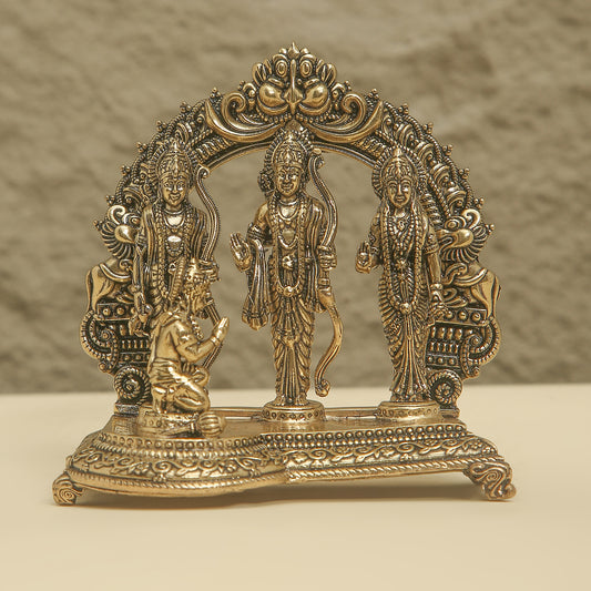 Decorative brass statue of three figures in a semi-circle on a textured surface