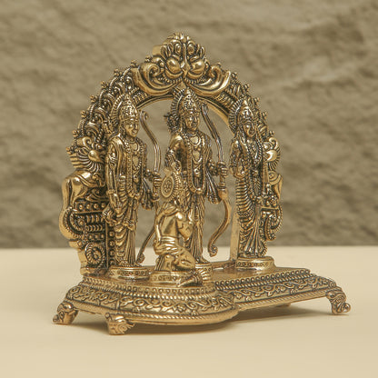 Decorative brass statue with intricate designs on a beige background