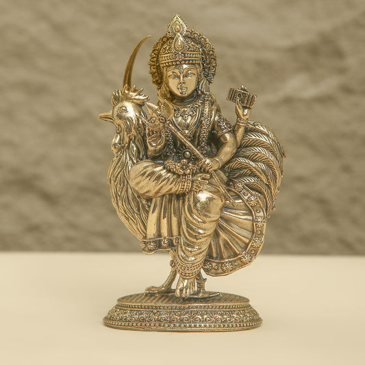 Bronze statue of a deity with a rooster on a beige background