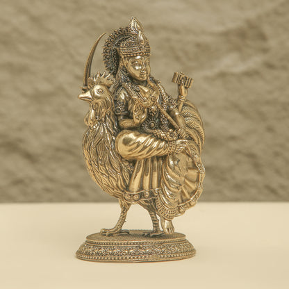 Bronze statue of a figure on a rooster with a textured background