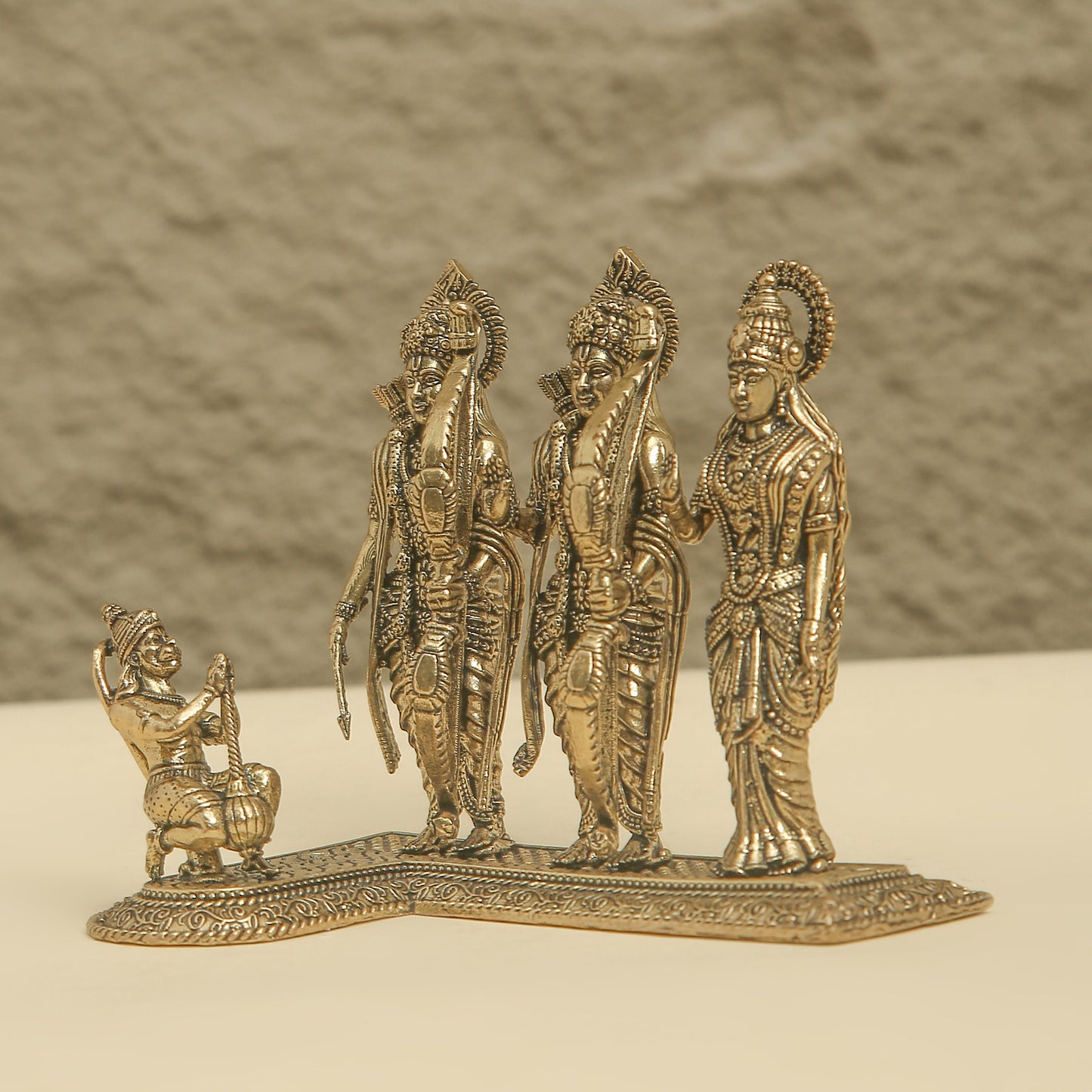 Bronze statue of three figures on a plain background