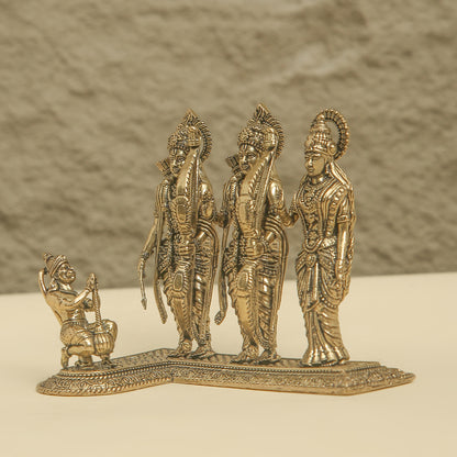 Bronze statue of three figures on a plain background