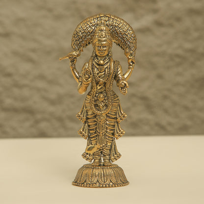Gold-colored statue of a deity on a beige background
