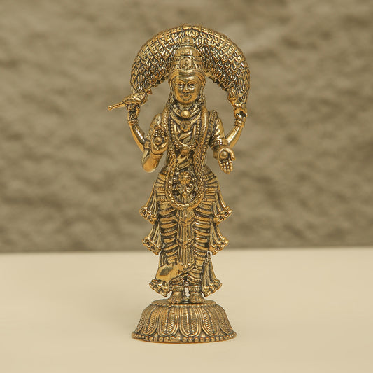 Gold-colored statue of a deity on a beige background