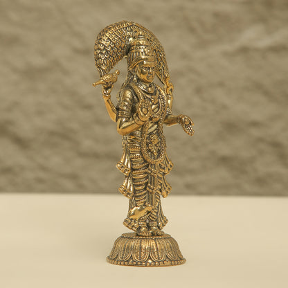 Gold-colored statue of a deity on a beige background